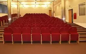 Sala audytoryjna 102 I piętro, ujęcie ze sceny przedstawiające czerwone miejsca siedzące pnące się w g&oacute;rę oraz schody.