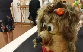 Kobieta ogląda wystawę prac plastycznych.