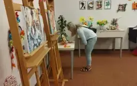 Trzy kobiety oglądają wystawę.