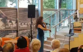 Koncert Jessiki Merstein. Kobieta gra na skrzypcach przed widownią.
