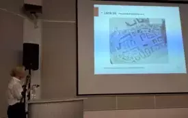 Agata Stępińska-Kaczmarczyk w trakcie przem&oacute;wienia, w centralnym punkcie slajd z prezentacji