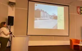 Agnieszka Dębska w trakcie wykładu, w centralnym punkcie slajd z prezentacji