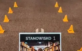 Uczniowie pokonują tor przeszk&oacute;d skacząc przez szarfy.