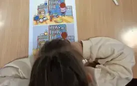 Dziewczynka szuka r&oacute;żnic na wydrukowanych obrazkach. 