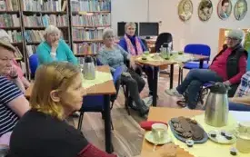 Pionowy widok na stoły i siedzace przy nich osoby