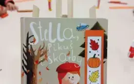 1.	Na pierwszym planie książka pt. &bdquo;Stella, Pikuś i skarby&rdquo; oraz zakładka w jesienne wzory. W tle dzieci tworzące własne zakładki. 