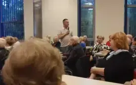 dr Przemysław Pawlak przemawia do mikrofonu wśr&oacute;d słuchającej go publiczności