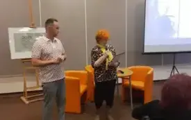 dr Przemysław Pawlak oraz Barbara Schroeder stoją na środku sali i witają puibliczność
