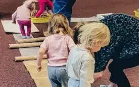 Dzieci pokonują budowlany tor przeszk&oacute;d złożony z tub, styropianu czy folii bąbelkowej.
