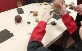 ręcę dziecka nawijają wł&oacute;czkę, osoba dorosła pomaga