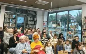 Uczestnicy siedzą na krzesłach ustawionych w rzędach.