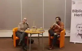 Agnieszka Kopaczyńska-Moskaluk oraz Michał Limboski siedzą na pomarańczowych fotelach i przemawiają do mikrofonu.
