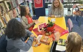 Trzy dziewczynki i kobieta siedzą przy stole