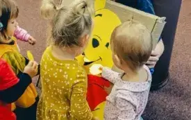 Dzień postaci z bajek 2 &ndash; Dzieci karmią Kubusia Puchatka papierowym miodkiem.