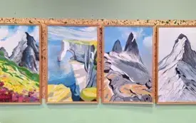 Cztery obrazy przedstawiające g&oacute;ry i formacje skalne wiszą na ścianie.
