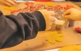 Przedszkolaki tworzą drzewko z pofarbowanego ryżu, fasoli i makaronu.
