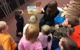 Pani bibliotekarka czyta dzieciom książkę.