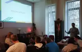 Dzieci i młodzież słuchają prowadzącego zajęcia