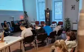 dzieci i młodzież słuchają głośnego czytania