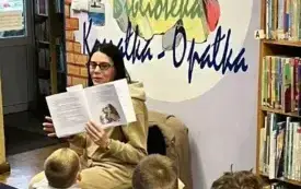 Kobieta czyta bajkę grupie dzieci.