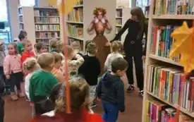 Dzieci doczepiają listki do sp&oacute;dnicy Pani Jesień. 