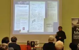 W centralnym punkcie wyświetlony slajd, z prawej strony Robert M. Jurga w trakcie wykładu i kilka os&oacute;b z publicznosci