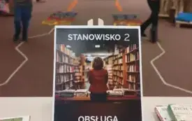 Plakat z napisem: Stanowisko 2. Obsługa czytelnik&oacute;w. W tle dzieci pokonujące tor przeszk&oacute;d z książkami.