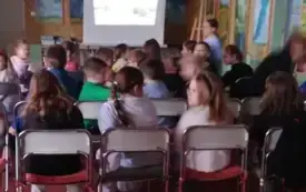 Dzieci oglądają zdjęcia ze Stan&oacute;w Zjednoczonych.