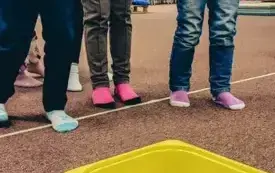 Dzieci wrzucają monetę do pudełka z wodą. 
