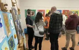 Otwarcie wystawy pt. "Poznajcie Nas". Na zdjęciu widoczne poszczeg&oacute;lne osoby, w tle prace.
