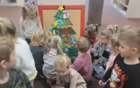 Dzieci ubierają filcową choinkę.