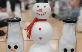 Na stole trzy sztuczne bałwanki. W tle dzieci