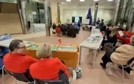 Wydawcy i czytelnicy zgromadzeni w holu słuchają Małgorzaty Pytlak (z tyłu) prezentującej książki Muzeum Lubuskiego