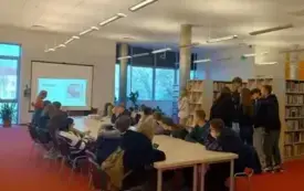 Młodzież rozwiązuje quiz biblioteczny.