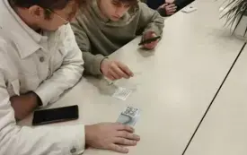 Dwoje uczni&oacute;w wypisuje rewers w Wypożyczalni Gł&oacute;wnej.