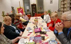 Klubowicze DKK podczas dyskusji na temat książki pt. "Serce nie siwieje" Hanny Bilińskiej-Stecyszyn. Na zdjęciu widocznych jest osiem os&oacute;b. Wszyscy siedzą przy udekorowanym świątecznie stole.