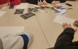 Uczniowie siedzą przy stoliku i rysują ilustracje do własnej legendy