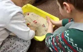 Uczestnicy zajęć szukają ukrytych w piasku robaczk&oacute;w.