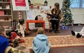 Pani Bibliotekarka czyta dzieciom książkę.