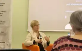 Prof. Mikołajczak siedzi w fotelu, trzyma mikrofon i opowiada o swojej książce
