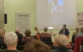 Uczestnicy zgromadzeni na spotkaniu, w tle prof. Mikołajczak i dr Urbanek