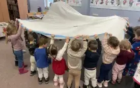 Dzieci w zabawie ruchowej z chustą animacyjną