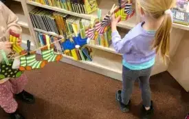 Mali uczestnicy zajęć zawieszają kolorowe skarpetki na sznurku.
