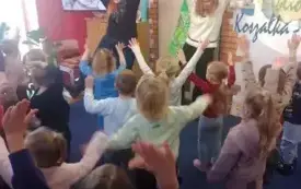 Dwie kobiety tańczą taniec z pokazywaniem z grupą przedszkolak&oacute;w