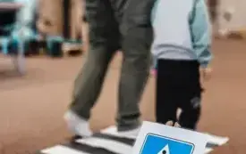 Dziecko wraz z rodzicem uczy się przechodzenia przez jezdnię.
