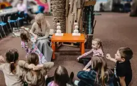 Bibliotekarka czyta dzieciom książkę w Oddziale Dziecięcym.