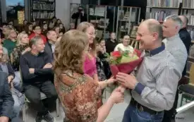 Para kobiet wręcza bukiet mężczyźnie.  