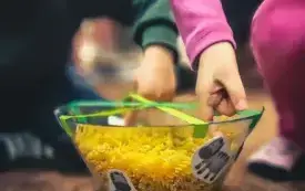 Dzieci wyciągają małe zebry ze szklanych pojemnik&oacute;w.