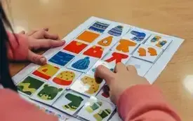 Dziewczynka przykłada elementy odzieży według wzoru i koloru .