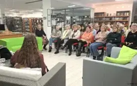 Na zdjęciu widoczne jest wielu miłośnik&oacute;w literatury. Wszyscy siedzą w bibliotece.
